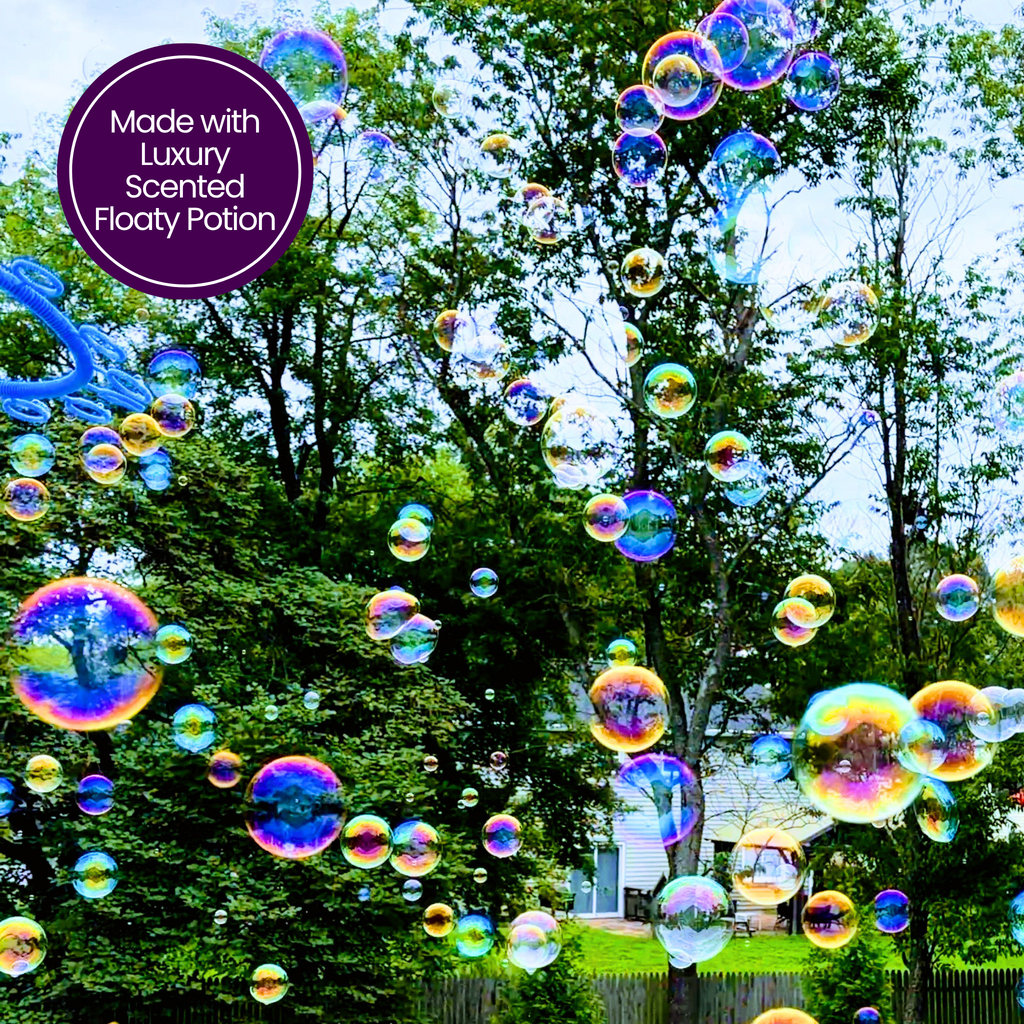 A cloud of colorful, iridescent floating bubbles drifting through a sunny backyard treescape, created with One Two Celebrate® Luxury Scented Floaty Potion.